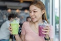 Woman holding glass of Green tea frappe and blueberry smoothies Royalty Free Stock Photo