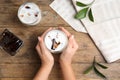 Woman holding glass of milk with delicious grass jelly at wooden table, top view Royalty Free Stock Photo