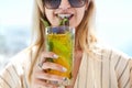 Woman holding a glass of passion fruit cocktail in Santorini background Royalty Free Stock Photo