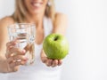 Woman holding glass of water and green apple. Royalty Free Stock Photo