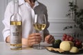 Woman holding glass of white wine at table with snacks, closeup Royalty Free Stock Photo