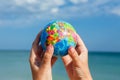 Woman holding globe of the Earth on a background of the sea.