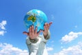 Woman holding a globe under blue sky Royalty Free Stock Photo