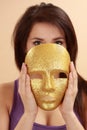 Woman holding gold mask