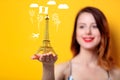 Woman holding golden Eiffel Tower souvenir