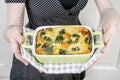 Woman holding a gratin in green bowl