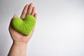 A woman holding a green crochet heart on her hands in white background, symbol of love and peace, shape of love heart, valentin Royalty Free Stock Photo