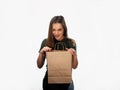 Woman is holding grocery shopping bag on white background. Light brown paper bag in hands. Isolated background. Royalty Free Stock Photo