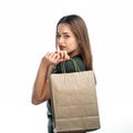 Woman is holding grocery shopping bag on white background. Young girl is holding light brown shopping bag behind back.