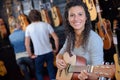 Woman holding guitar in guitar store