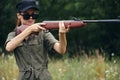 Woman holding a gun aiming sunglasses green leaves