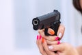 Woman holding gun in hand at home. Focus hand of young women using black gun protection from danger gesture killer Royalty Free Stock Photo