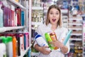 Woman holding hair care products at cosmetics store Royalty Free Stock Photo