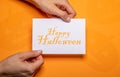 Woman holding halloween letter on orange background