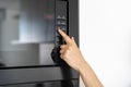 Woman holding hand on black microwave button Royalty Free Stock Photo