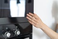 Woman holding hand on black microwave door Royalty Free Stock Photo