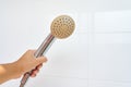 Woman holding in hand corroded limescale calcified old shower head hanging from a stand inside cabin Royalty Free Stock Photo