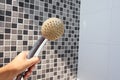 Woman holding in hand corroded limescale calcified old shower head hanging from a stand inside cabin Royalty Free Stock Photo