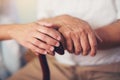 Woman holding hand of old man with walking stick Royalty Free Stock Photo