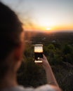 Woman taking picture of sunset with smartphone