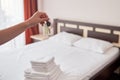 Woman holding in hand room key with blank label at hotel suite, copy space. Bedroom interior in blur.