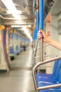 Woman holding hand on vertical handrail in subway car. Royalty Free Stock Photo