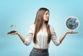 Woman holding handful of soil with plant in one hand and globe in the other Royalty Free Stock Photo