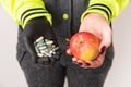 A woman holding in hands an apple and capsules with vitamins. Royalty Free Stock Photo