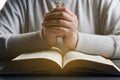 Woman holding hands clasped while praying over Bible at wooden table, closeup Royalty Free Stock Photo