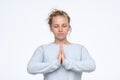 Woman holding hands in namaste or prayer, keeping eyes closed while meditating Royalty Free Stock Photo