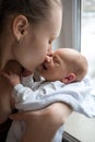 Woman holding on hands a newborn. Mother kissing her son. Portrait of young family. Happy family life. Man was born Royalty Free Stock Photo