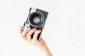 Woman holding in hands old vintage camera. Girl photographer and film camera Royalty Free Stock Photo