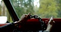 Woman is holding hands on steering wheel looks like a chain and moving handle inside car Royalty Free Stock Photo