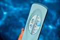 Woman holding hands in a water thermometer for pool during warm summer days. High temperature of waterpool 30 degrees Celsius Royalty Free Stock Photo