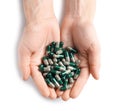 Woman holding heap of green spirulina capsules on white background Royalty Free Stock Photo