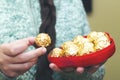 Woman holding heart box of golden premium chocolate sweets