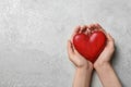 Woman holding heart on grey stone background, space for text. Donation concept Royalty Free Stock Photo