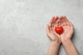 Woman holding heart on grey stone background, top view with space for text Royalty Free Stock Photo