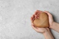 Woman holding heart on grey stone background, space for text. Donation concept Royalty Free Stock Photo