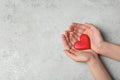 Woman holding heart on grey stone background, top view. Donation concept Royalty Free Stock Photo