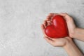 Woman holding heart on grey stone background, top view. Donation concept Royalty Free Stock Photo