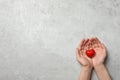 Woman holding heart on grey stone background, space for text. Donation concept Royalty Free Stock Photo