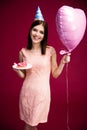 Woman holding heart shaped balloon and donut with candle Royalty Free Stock Photo