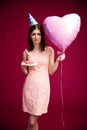 Woman holding heart shaped balloon and donut with candle Royalty Free Stock Photo