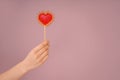 Woman holding heart shaped lollipop on color background Royalty Free Stock Photo