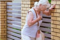 Woman is holding her chest while standing on the street, heart attack concept Royalty Free Stock Photo