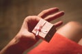 Woman holding in her hand a very small pink gift box above her k Royalty Free Stock Photo