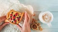 Woman holding in her hands a delicious pastrie with berries, on wooden table is coffee and brown sugar cubes