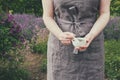 Woman holding in her hands a mortar of healing herbs. Herbalist collects medicinal plants in garden