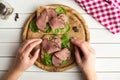 Woman holding in her hands open roast beef sandwich with salad and pepper on rustic wooden plate. Royalty Free Stock Photo